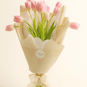Ramo Tulipán de Ensueño Fioretta con tulipanes rosados envueltos en papel marfil y lazo de organza. Arreglo floral elegante y minimalista Fioretta.