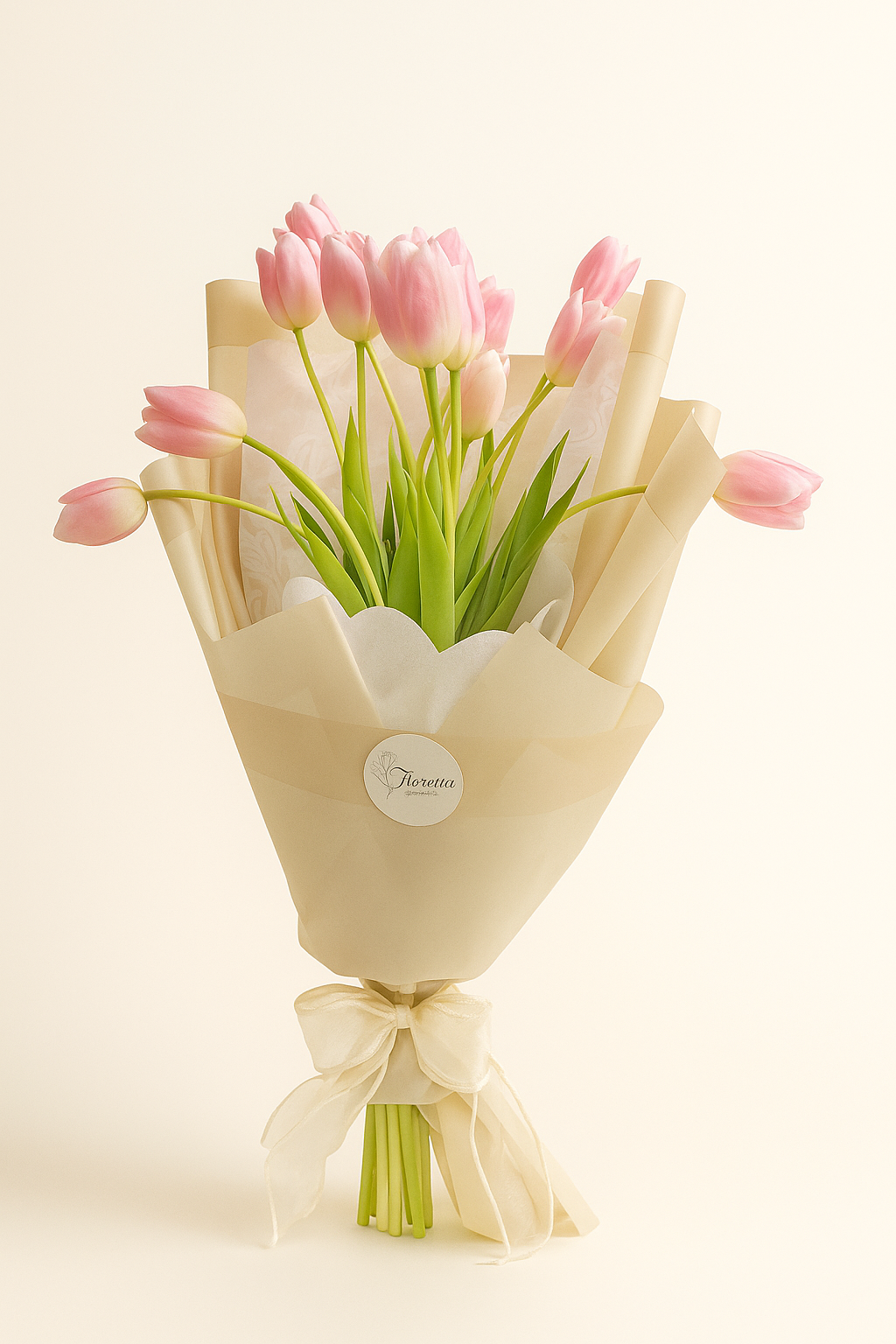 Ramo Tulipán de Ensueño Fioretta con tulipanes rosados envueltos en papel marfil y lazo de organza. Arreglo floral elegante y minimalista Fioretta.