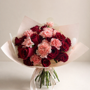 Ramo de 24 rosas rojas con claveles rosados en envoltorio elegante estilo premium
